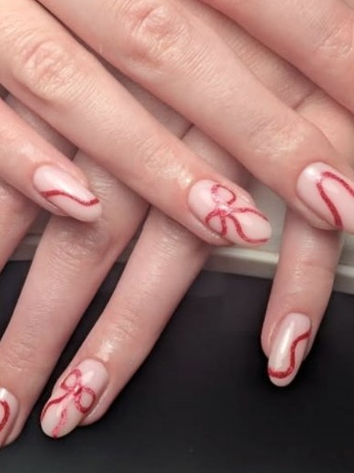 Sheer pink nails with red ribbon bows