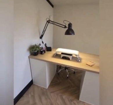 The studio: a white room with a wooden nail desk, black desk lamp and herringbone floor